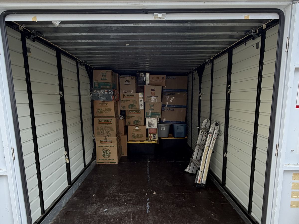 A moving container neatly loaded with boxes stacked at the back